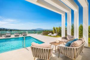 a home with a swimming pool and a patio at Villa Vatia 3 in Tragaki