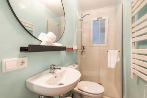 ein Badezimmer mit Waschbecken, Toilette und Spiegel in der Unterkunft Suite 1 in Maó + 11 Fotos