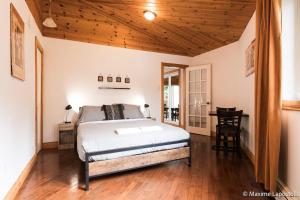 a bedroom with a bed and a wooden ceiling at La Tour Boisée with Private Spa & Pool, Pool Table in Sainte Béatrix