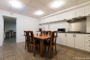 a kitchen with a wooden table and chairs at La Tour Boisée with Private Spa & Pool, Pool Table in Sainte Béatrix +42 photos