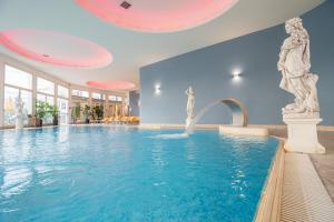a swimming pool with a fountain in a building at Hotel Terme Helvetia in Abano Terme +76 photos