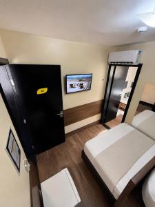 a small room with a bed and a tv at Uny Hotéis Brás in São Paulo +31 photos