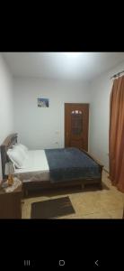 a bedroom with a large bed with a wooden headboard at Vila Ameli Bucimas in Buçimas +7 photos