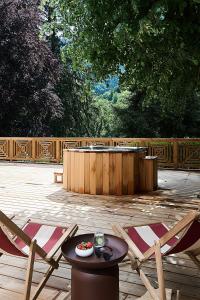 a patio with a table and two chairs and a hot tub at Le Parc - Hôtel & Spa in Allevard