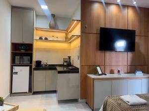 a small kitchen with a tv on the wall at Residencial Ibiapaba Flat 16 - Com piscina e ótima localização in Camocim