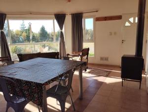 a dining room with a table and chairs and a large window at APA Las Condalias in Puerto Madryn