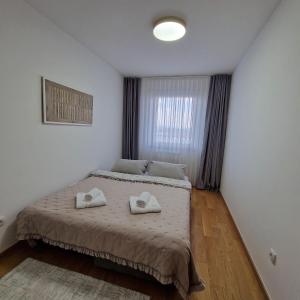 a bedroom with a bed with two pillows on it at Apartman KOMFORT 33, Near Sarajevo Airport & Free Parking in Donje Mladice