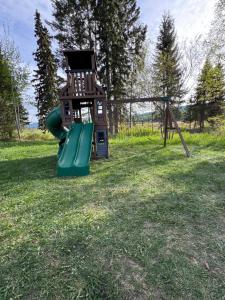 a playground with a slide in the grass at Nakiska Bear Ranch in Clearwater