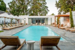 a swimming pool with lounge chairs and a resort at Erinvale Estate Hotel & Spa in Somerset West