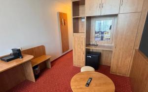 a room with a table and a chair in a room at DORMERO Express Hotel Passau in Passau +9 photos