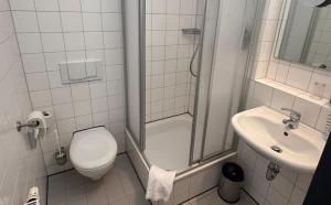 a small bathroom with a toilet and a sink at DORMERO Express Hotel Passau in Passau