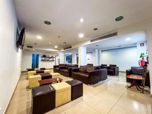 a large lobby with couches and tables and a screen at Hotel 13 de Outubro By Umbral in Fátima