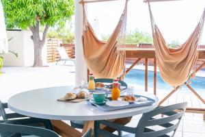 a table with breakfast food on a patio with hammocks at Ilot Bleu in Boucan Canot