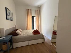 a small bedroom with a bed and a mirror at Cosy home in Three Cities in Taʼ Penza