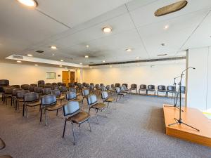 a conference room with chairs and a podium at Hotel 13 de Outubro By Umbral in Fátima