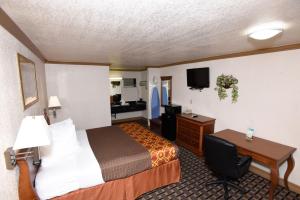a hotel room with a bed and a desk at Best Budget Inn Anaheim in Anaheim