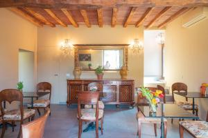 ein Esszimmer mit Tischen, Stühlen und einem Spiegel in der Unterkunft Relais Monastero in Podenzano