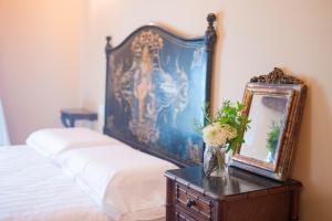ein Schlafzimmer mit einem Bett, einem Spiegel und einem Tisch in der Unterkunft Relais Monastero in Podenzano