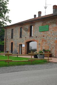 ein Backsteingebäude mit einer Bank davor in der Unterkunft Relais Monastero in Podenzano