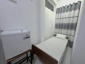 a small room with a bed and a window at White House Galaha in Galaha Town
