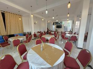 a dining room with tables and chairs and a room with a screen at White House Galaha in Galaha Town