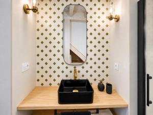 a bathroom with a black sink and a mirror at La Casuca del Olivo - casa con jardín cerca de Cabárceno y Santander in Ceceñas +18 photos