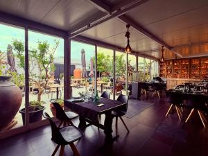 a dining room with a table and chairs and windows at Casa Serra & Mar in Azeitao