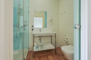 a bathroom with a shower and a sink and a toilet at Casa de São Bento by PURUS in Coimbra +48 photos