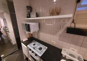 a small kitchen with a stove and a microwave at SUH Leme 04 Studio Comfort in Rio de Janeiro
