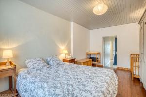 a bedroom with a bed with a blue and white bedspread at Le Saint Roch in Villeréal