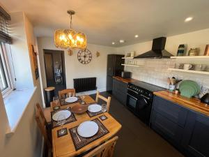 a kitchen with a wooden table with plates on it at Copper Cottage in Devizes +9 photos