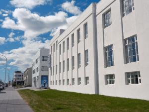 ein weißes Gebäude an einer Straßenseite in der Unterkunft Mjólk Hotel in Reykjavík