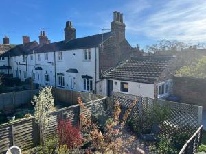 a white house with a fence in front of it at Copper Cottage in Devizes