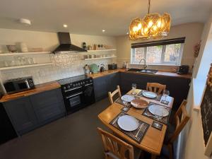a kitchen with a wooden table with plates on it at Copper Cottage in Devizes