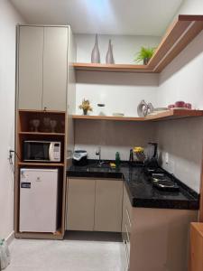 a kitchen with a refrigerator and a microwave at Residencial Ibiapaba FLAT 31 - com piscina e ótima localização in Camocim +2 photos