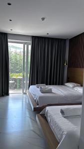 a bedroom with two beds and a large window at Vila Klea in Ksamil