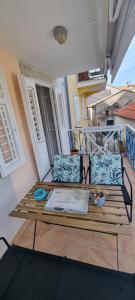 a wooden bench on a balcony with a table at Sea La Vie in Valun