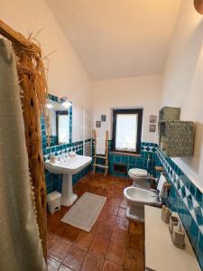 a bathroom with two toilets and a sink and a mirror at Antico Stazzo Gallurese in Luogosanto +12 photos