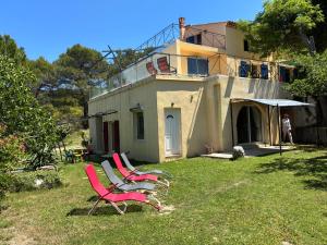 a group of chairs sitting in the grass in front of a house at Villa Boulou in Rognes