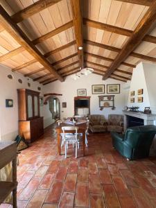 a living room with wooden ceilings and a table at Antico Stazzo Gallurese in Luogosanto
