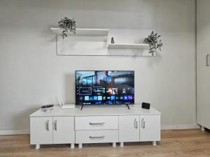 a white entertainment center with a flat screen tv at Konstanzer 44 - Urban Studio - Iulius Mall - AC in Iaşi