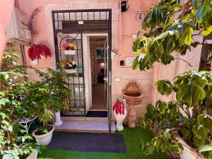 an entrance to a pink building with potted plants at Le Chalet Palermo Centro in Palermo
