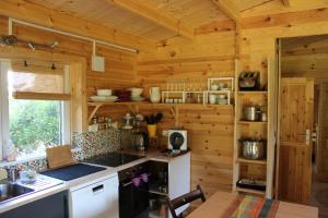 a kitchen in a wooden cabin with a sink and a table at Chalet Lohr in Lohr