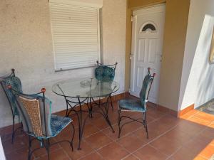 a glass table and chairs in a room at Nice House on the Beach in Balatonfenyves