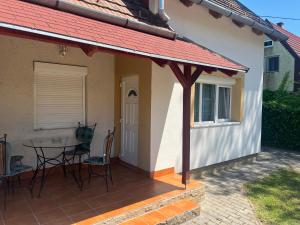 a patio with a table and chairs next to a house at Nice House on the Beach in Balatonfenyves