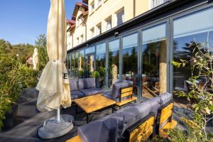 a patio with a table and an umbrella at BURSZTYN - BERNSTEIN SPA & Wellness in Dąbki