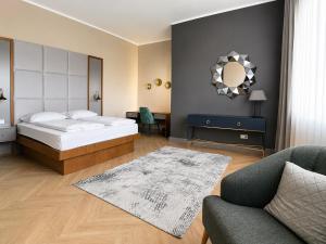 a bedroom with a bed and a couch and a chair at SOLWO Suites Berlin Charlottenburg in Berlin