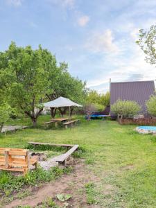 a picnic table and benches in a field at Delta Rest House in Nor Hachyn