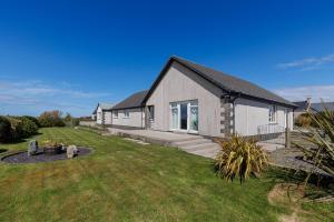 a house with a grass yard in front of it at Seaview Bed & Breakfast in Isle of Lewis