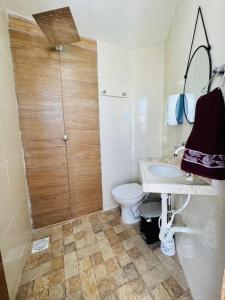 a bathroom with a toilet and a sink and a shower at Casa Perfeita Paracuru in Paracuru